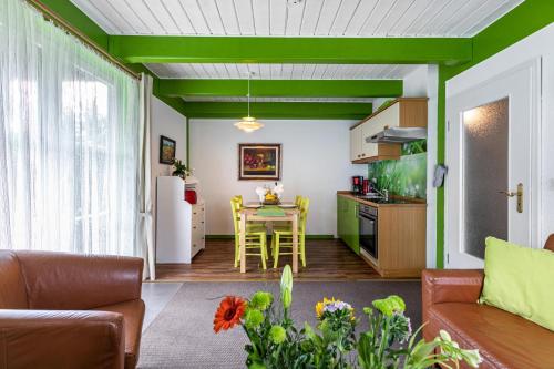 a living room with a table and a kitchen with green ceilings at Atlanta Pur in Pellworm