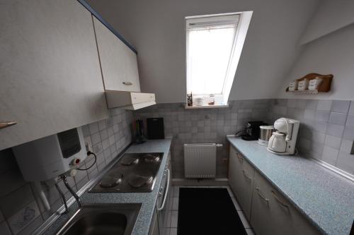 a small kitchen with a sink and a stove at Sielhuus in Neuharlingersiel
