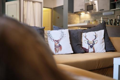 a person sitting on a couch with pillows on it at Grand appt au pieds des pistes in Chamrousse