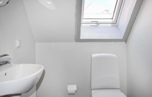a bathroom with a sink and a toilet and a window at Beautiful Apartment In Simrishamn in Simrishamn