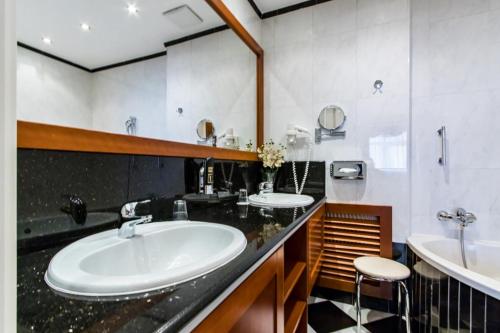 a bathroom with two sinks and a black counter at Hotel Corvinus Vienna in Vienna