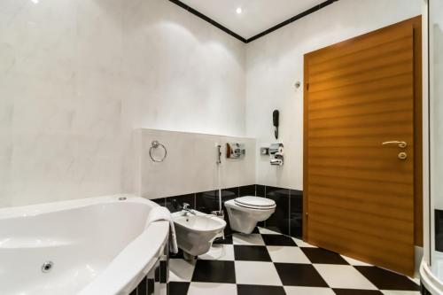 a bathroom with a black and white checkered floor at Hotel Corvinus Vienna in Vienna