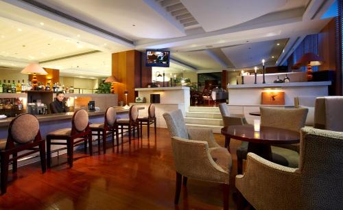 a restaurant with tables and chairs and a bar at Hotel Royal Hsinchu in Hsinchu City