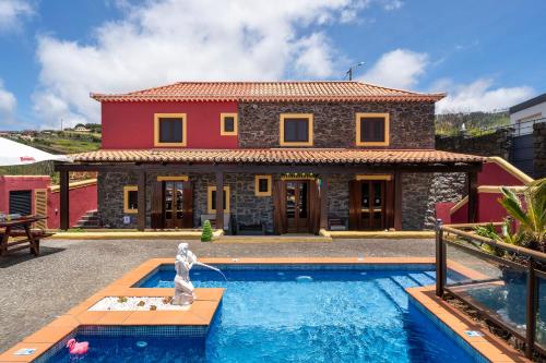 a villa with a swimming pool in front of a house at Villa Roque by An Island Apart in Calheta