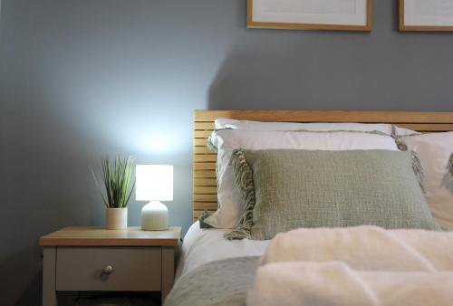a bedroom with a bed with a lamp on a night stand at New, Luxury Apartment in Town Centre in Cheltenham