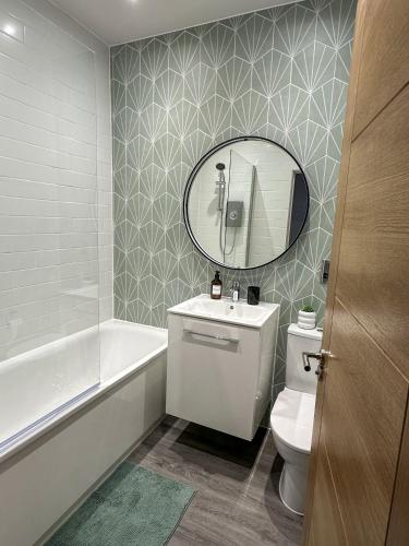 a bathroom with a white toilet and a mirror at New, Luxury Apartment in Town Centre in Cheltenham