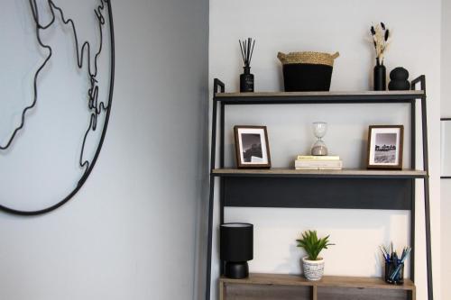 a shelf with pictures and a mirror on a wall at New, Luxury Apartment in Town Centre in Cheltenham