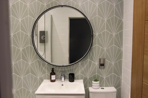 a bathroom with a sink and a mirror at New, Luxury Apartment in Town Centre in Cheltenham