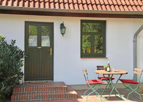 a table and chairs on a patio with a black door at FeWo Fehmarn Mecklenburg Pool Alte Schule Barlin in Dargun