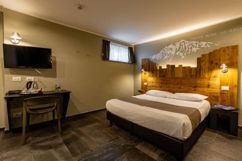 a bedroom with a bed and a desk and a tv at Monte Emilius in Aosta