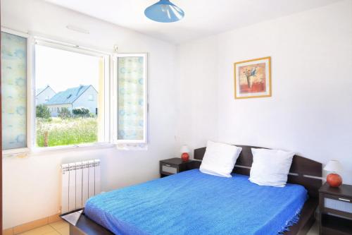 a bedroom with a blue bed and a window at Les PerceNeige - Maison 85 m² à Port-Bail-Sur-Mer in Portbail