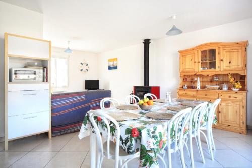une cuisine avec une table et des chaises dans une cuisine dans l'établissement Les PerceNeige - Maison 85 m² à Port-Bail-Sur-Mer, à Portbail