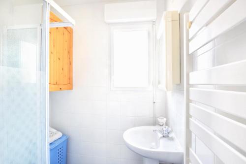 a white bathroom with a sink and a window at Les Tamaris du Nord - Maison à 300m de la plage in Portbail