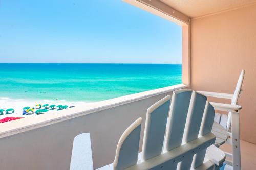 a view of the beach from a balcony with a beach chair at The Surf Shack in Destin