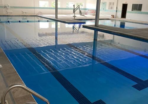 an empty swimming pool with blue water at Cozy Texoma Hideaway with Tanglewood Resort Access in Pottsboro