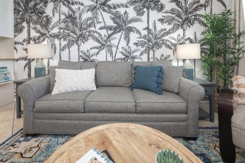 a living room with a couch and palm trees mural at The Surf Shack in Destin