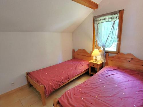 une chambre avec deux lits et une fenêtre dans l'établissement Charmant Duplex à Chaillol avec Balcon Sud, WIFI et Parking Optionnel, Capacité 5 Personnes - FR-1-393-14, à Saint-Michel-de-Chaillol