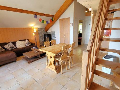 un salon avec une table et des chaises en bois dans l'établissement Charmant Duplex à Chaillol avec Balcon Sud, WIFI et Parking Optionnel, Capacité 5 Personnes - FR-1-393-14, à Saint-Michel-de-Chaillol