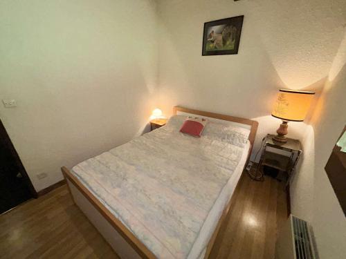 - une petite chambre avec un lit et deux lampes dans l'établissement Appartement cosy 2 pièces, 6 couchages, balcon, garage et casier à skis, Demi-Quartier - FR-1-597-9, à Demi-Quartier