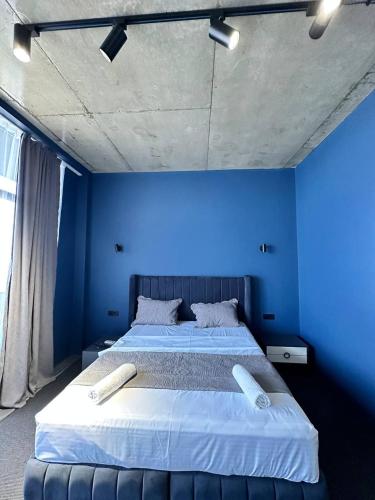 a blue bedroom with a large bed with blue walls at Hotel black sea in K'obulet'i