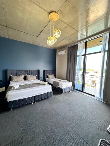 a bedroom with two beds and a large window at Hotel black sea in K'obulet'i