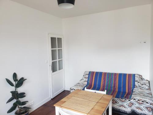 un salon avec un canapé et une table dans l'établissement Yogapart, au Kremlin-Bicêtre