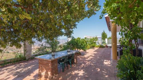 a table and chairs on a patio with a view at Casa La Fajara 2 Canillas de Aceituno by Ruralidays in Canillas de Aceituno