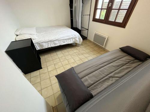- une chambre avec deux lits et du carrelage dans l'établissement Jolie villa rénovée, 900m plage, jardin clos, animaux admis, parking, balades corniche vendéenne - FR-1-324-565, à Saint-Hilaire-de-Riez