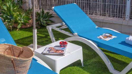 a blue and white chair and a table with a book at Casa La Fajara 2 Canillas de Aceituno by Ruralidays in Canillas de Aceituno