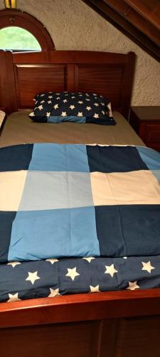 a bed with a blue and white comforter with stars on it at Quinta dos Cinco Sentidos in Feteira Grande