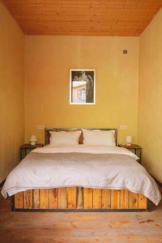 a bedroom with a bed with a wooden headboard at Arte in Kazbegi in Stepantsminda