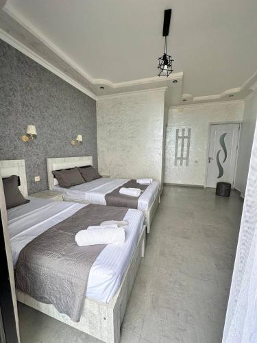 a bedroom with two beds with towels on them at Hotel black sea in K'obulet'i