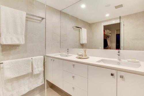 a white bathroom with a sink and a mirror at Goldsborough Place Apartments in Brisbane