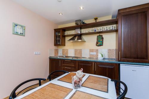a kitchen with a table with chairs and a refrigerator at Prie Ąžuolo in Juodkrantė