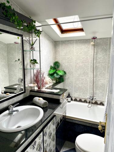 a bathroom with a sink and a tub and a toilet at Casa A Codela in Combarro