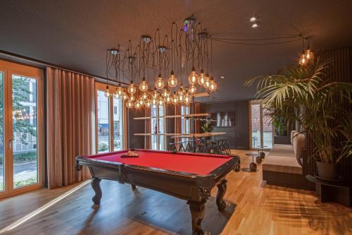 a room with a pool table and a chandelier at B5 Apartments in Karlsruhe