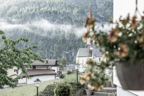 a small village with a church in the mountains at Vera Monti in Holzgau