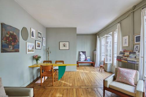 un salon avec une table et des chaises dans l'établissement Charming 1BR rue des Martyrs, à Paris
