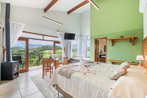 a bedroom with a bed and a table and a fireplace at Vertentes da Mantiqueira - Chalés in Santo Antônio do Pinhal