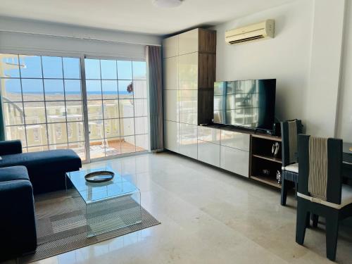 a living room with a couch and a tv at Paraiso Ocean Panorama in Palm-Mar