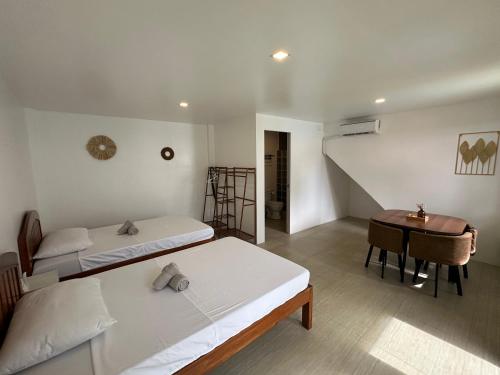 a bedroom with two beds and a desk and a staircase at Kasamigos Guesthouse with Fast Internet in Puerto Princesa City