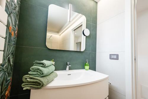 a bathroom with a white sink and a mirror at La Collina di Montegrappa - Suites with Heated Private Pool - Suites with Shared Pool in Tuglie