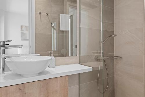 a bathroom with a sink and a glass shower at Serenity Waves Villa 9 in Sophtadhes