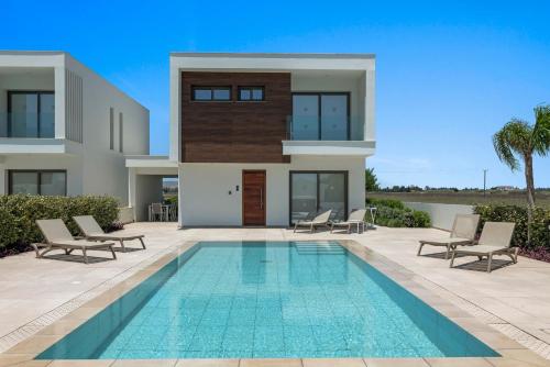 a villa with a swimming pool in front of a house at Serenity Waves Villa 9 in Sophtadhes