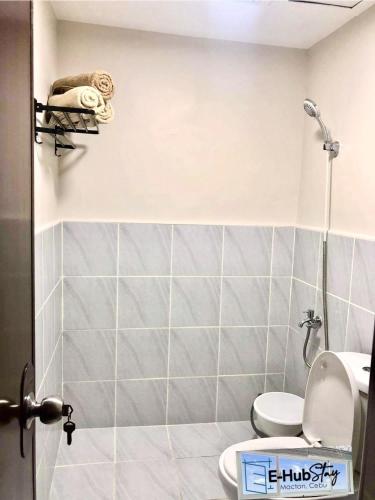 a small bathroom with a toilet and a shower at Luxurious Deluxe Apartment - EhubStay Mactan Cebu - Saekyung Condo Looc in Lo-oc
