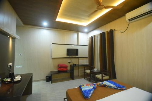 a room with a bed and a room with a screen at R Empire Revtree in Dāvangere