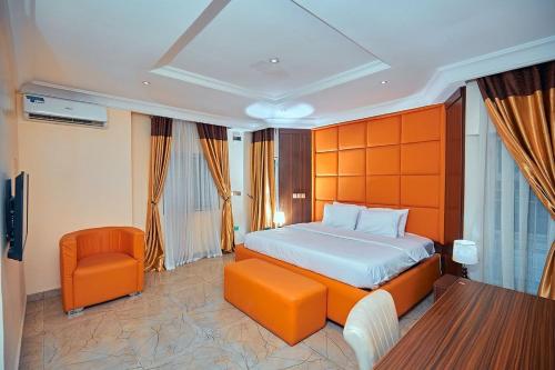 a bedroom with an orange bed and a chair at Apartment550 in Abuja