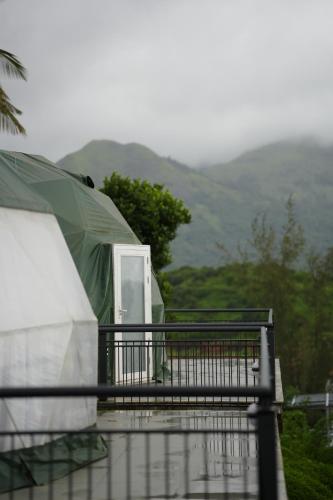 a tent on top of a house with mountains in the background at Dam View Glamps by SZ in Padinjarathara