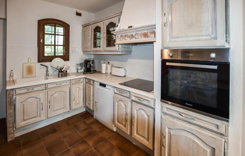 une grande cuisine avec des armoires et des appareils en bois dans l'établissement Amazing Home In Beaumont-De-Pertuis, à Beaumont-de-Pertuis