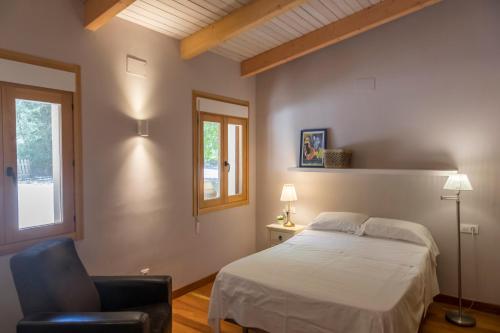 a bedroom with a bed and a chair and a window at La Casita de Cabrejas in Jábaga